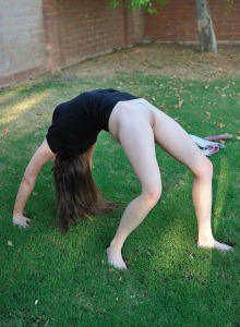 Beautiful sexy flexible Orianna doing exercises in light grey tight pants outdoor